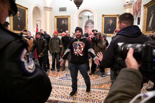 Douglas Austen Jensen of Iowa, a supporter of President Donald Trump wearing a QAnon shirt, confronts police as Trump supporters demonstrate on the second floor of the U.S. Capitol near the entrance to the Senate after breaching security defenses, in Washington, U.S., January 6, 2021.         REUTERS/Mike Theiler