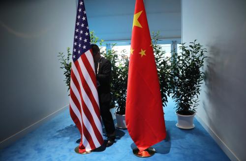 FILE PHOTO: Chinese official prepares the flags for the China-USA bilateral meeting at the G20 leaders summit in Hamburg, Germany July 8, 2017. REUTERS/Carlos Barria