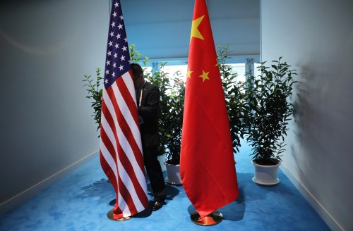 FILE PHOTO: Chinese official prepares the flags for the China-USA bilateral meeting at the G20 leaders summit in Hamburg, Germany July 8, 2017. REUTERS/Carlos Barria