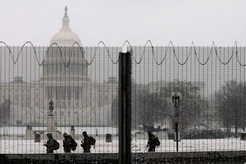 FILE PHOTO: National Guard members stand in the snow on duty, in front of the U.S. Capitol behind protective fencing, in Washington, U.S., January 31, 2021. REUTERS/Cheriss May/File Photo