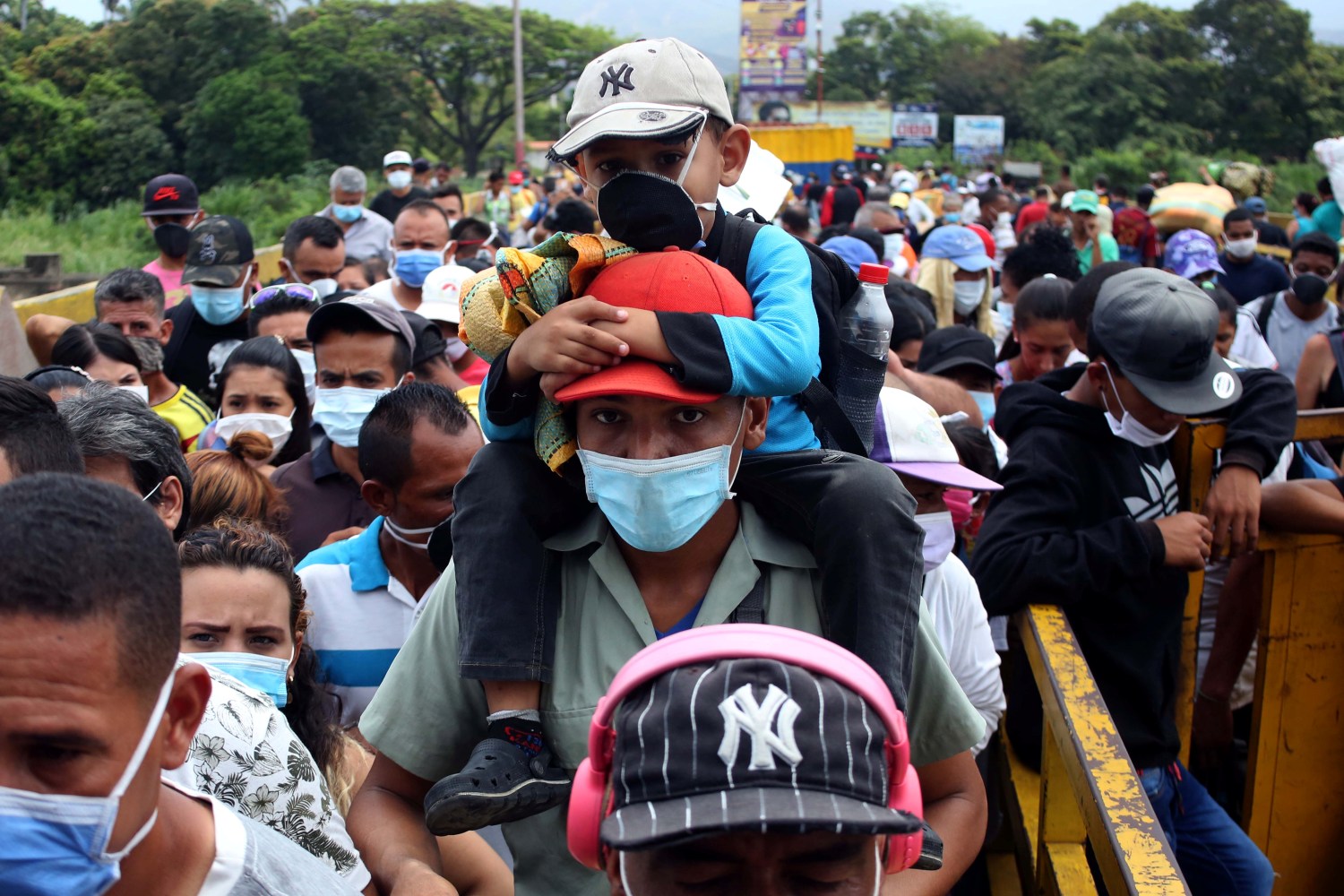 People wearing protective face masks line up to cross the border between Colombia and Venezuela at Simon Bolivar international bridge in Cucuta, Colombia March 12, 2020. REUTERS/Carlos Eduardo Ramirez