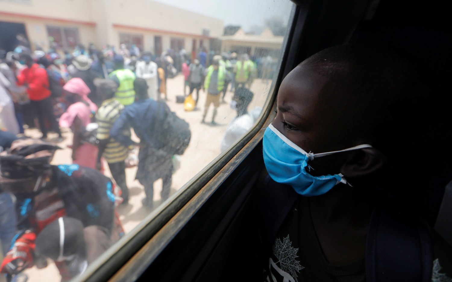 A boy looks out of a bus window as teachers prepare to board government chartered buses to go back to schools of countryside towns, scheduled to reopen next week, amid travel bans between regions due to the coronavirus disease (COVID-19) outbreak, in Dakar, Senegal May 27, 2020. REUTERS/Zohra Bensemra     TPX IMAGES OF THE DAY