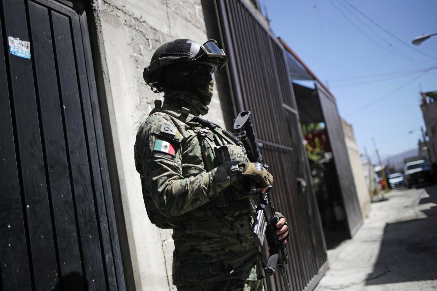 A member of the Mexican National Guard observes as health workers give instructions before administering a dose of the AstraZeneca coronavirus disease (COVID-19) vaccine to Rogelio Villanueva, 90, at his home at Milpa Alta municipality in Mexico City, Mexico February 18, 2021. REUTERS/Henry Romero