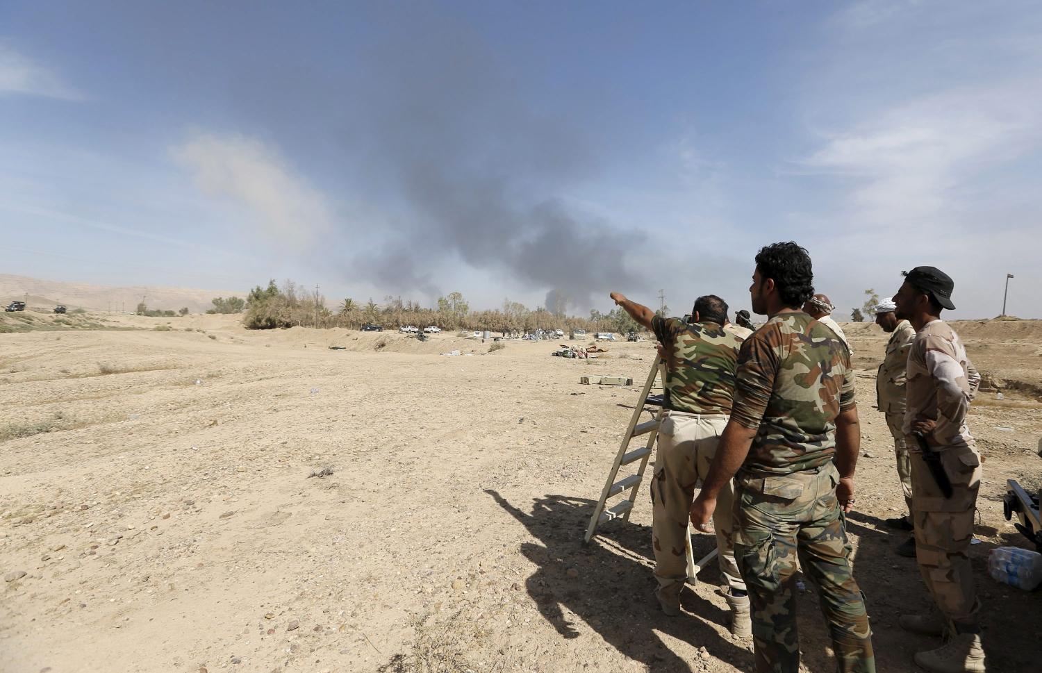 Shi'ite fighters gather to fight against Islamic State militants in al-Fatha, northeast of Baiji, October 18, 2015. Iraqi forces backed by Shi'ite militia fighters say they have retaken a mountain palace complex of former President Saddam Hussein from Islamic State fighters, as government forces push ahead on a major offensive against the insurgents.   REUTERS/Thaier Al-Sudani