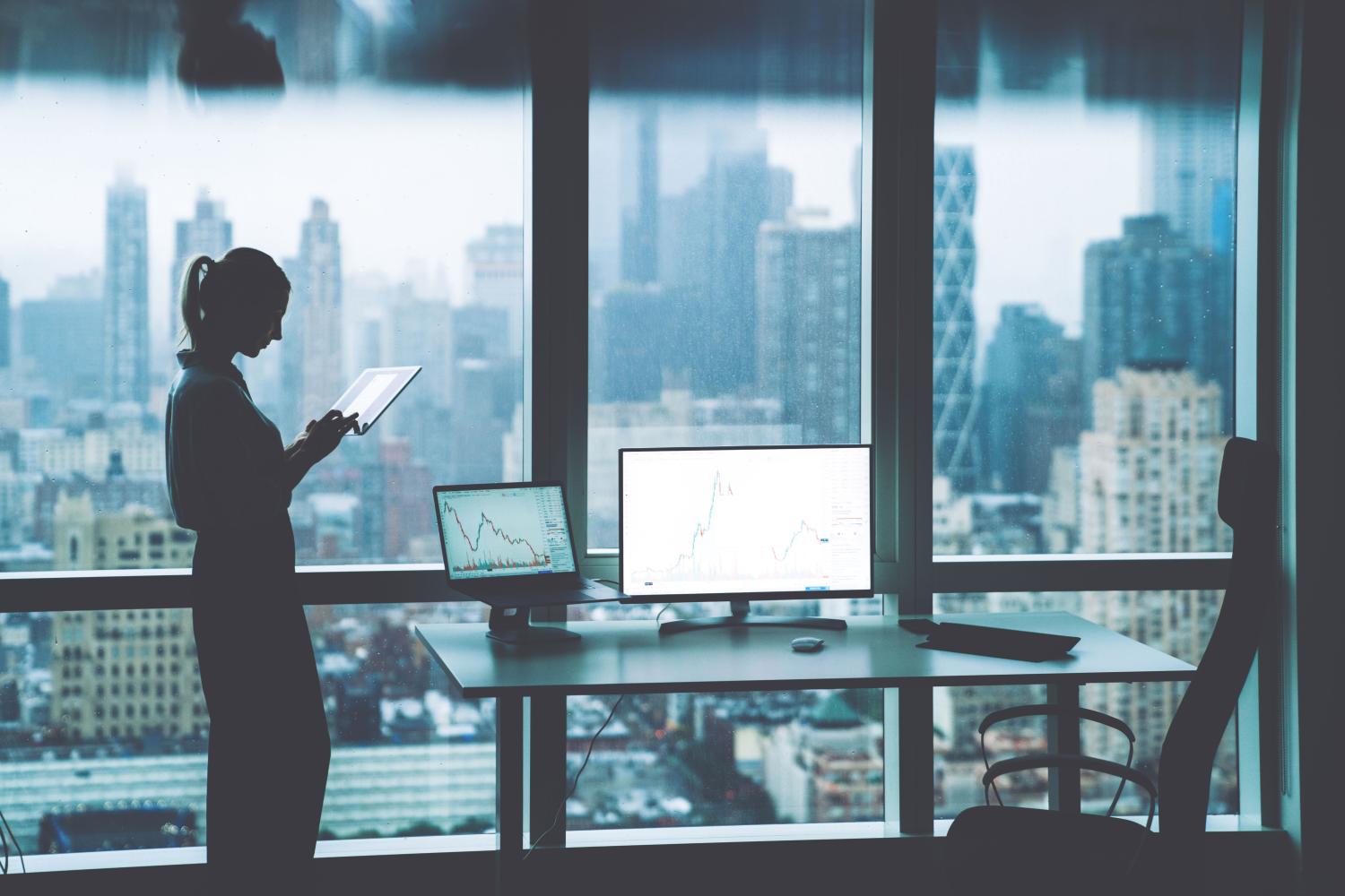 Woman working while standing in front of office window