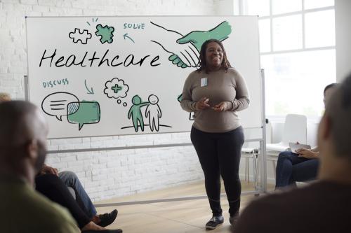 Woman talking about healthcare to a group of people.