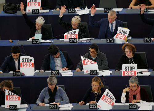 Members of the European Parliament hold placards for a campaign called "Rights for People, Rules for Corporations Ð Stop ISDS" as they take part in a voting session in Strasbourg, France, February 13, 2019. REUTERS/Vincent Kessler