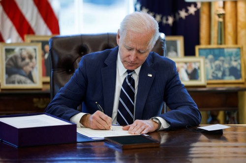 U.S. President Joe Biden signs the American Rescue Plan, a package of economic relief measures to respond to the impact of the coronavirus disease (COVID-19) pandemic, inside the Oval Office at the White House in Washington, U.S., March 11, 2021. REUTERS/Tom Brenner