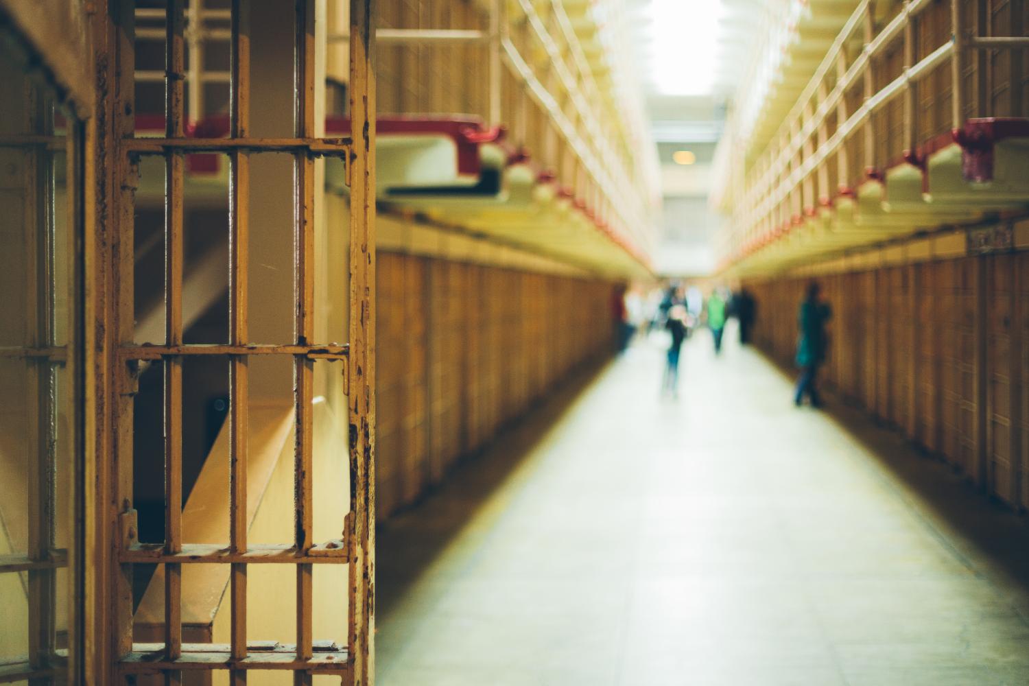 Hallway in a prison with people out of focus.