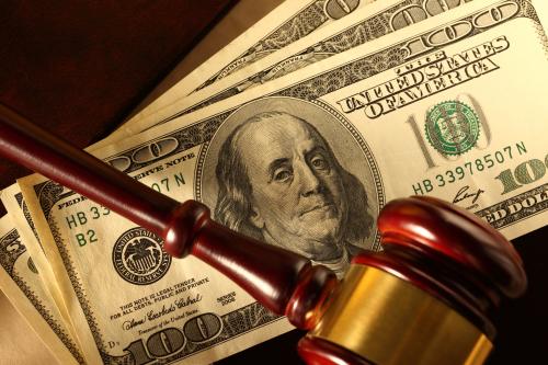 Gavel on a pile of 100 dollar bills