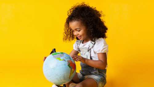 A girl looks at a globe.