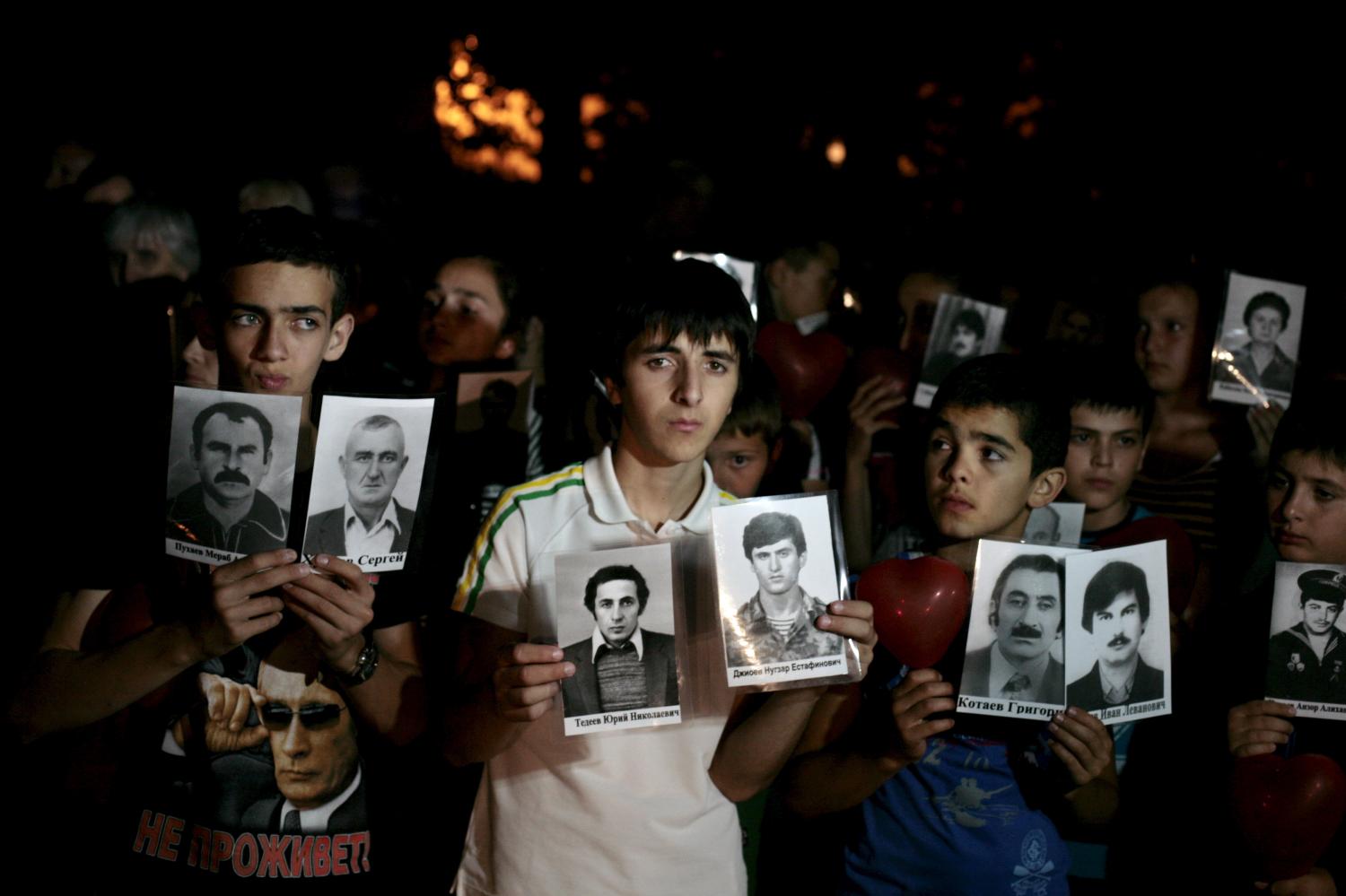 Participants hold portraits of people killed during Georgia's conflict with Russia over the breakaway region of South Ossetia in 2008, during a commemoration ceremony in Tskhinvali, Georgia, August 7, 2015. Picture taken August 7, 2015.  REUTERS/Kazbek Basayev