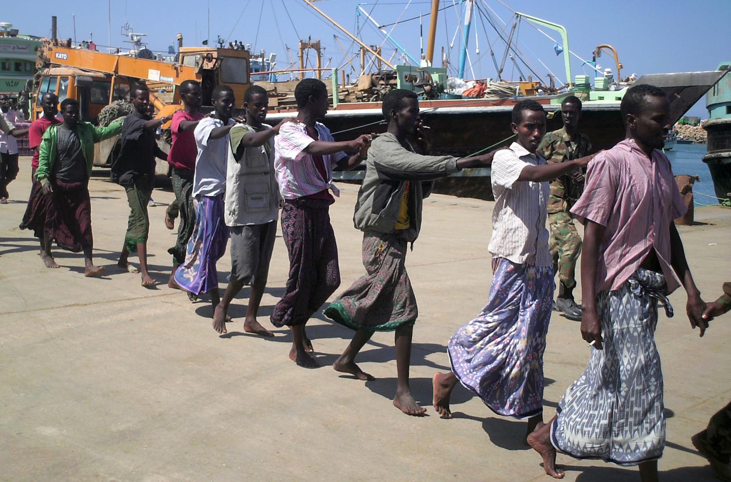 Somali pirates captured by French forces in the Gulf of Aden are paraded at the northern port town of Bosasso, November 18, 2009. French navy handed over 12 pirates captured in the Indian Ocean to the authorities in the semi-autonomous northern Somali region of Puntland, its deputy police commander Mohamed Said Jaqanaf told Reuters. REUTERS/Abdiqani Hassan (SOMALIA CONFLICT SOCIETY CRIME LAW)