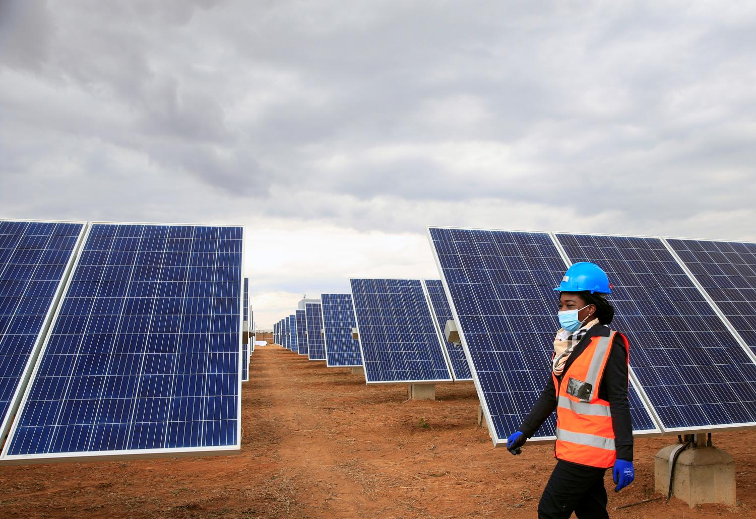 A worker walks past solar panels at Centragrid power plant in Nyabira, Zimbabwe, June 22, 2020. Picture taken June 22, 2020. REUTERS/Philimon Bulawayo