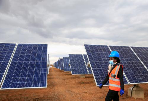 A worker walks past solar panels at Centragrid power plant in Nyabira, Zimbabwe, June 22, 2020. Picture taken June 22, 2020. REUTERS/Philimon Bulawayo