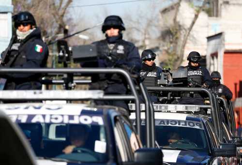 Federal police officers stand on the back of pick-up trucks while leaving a patio of the building housing the Assistant Attorney General's Office for Special Investigations on Organized Crime (SEIDO) in Mexico City February 27, 2015. Mexico has captured the country's most wanted drug lord still at large, Servando "La Tuta" Gomez, police said on Friday, in a boost for President Enrique Pena Nieto as he grapples with grisly gang violence. Gomez, 49, was the prime target of Pena Nieto's drive to regain control of Michoacan, a violent western state wracked by clashes between Gomez's Knights Templar cartel and heavily-armed vigilantes trying to oust them.    REUTERS/Edgard Garrido (MEXICO - Tags: DRUGS SOCIETY CRIME LAW CIVIL UNREST)
