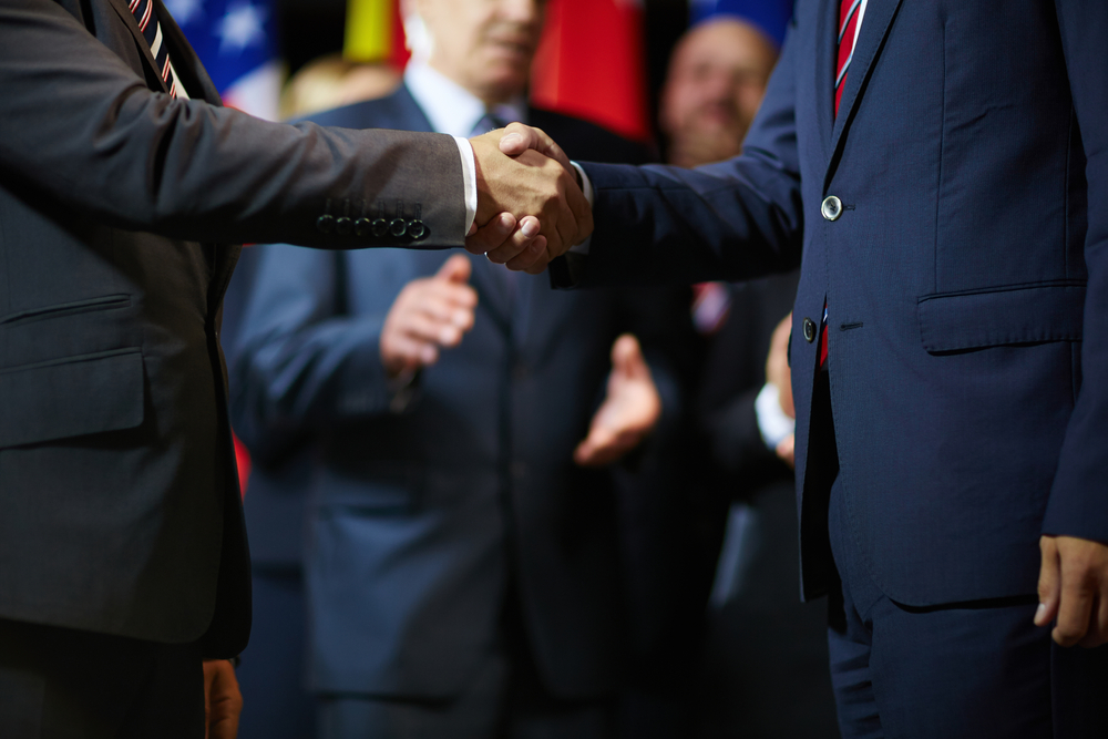 Two men in suits shaking hands