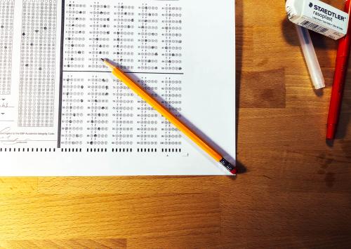 A top-down view of a multiple-choice test on white paper and a pencil.