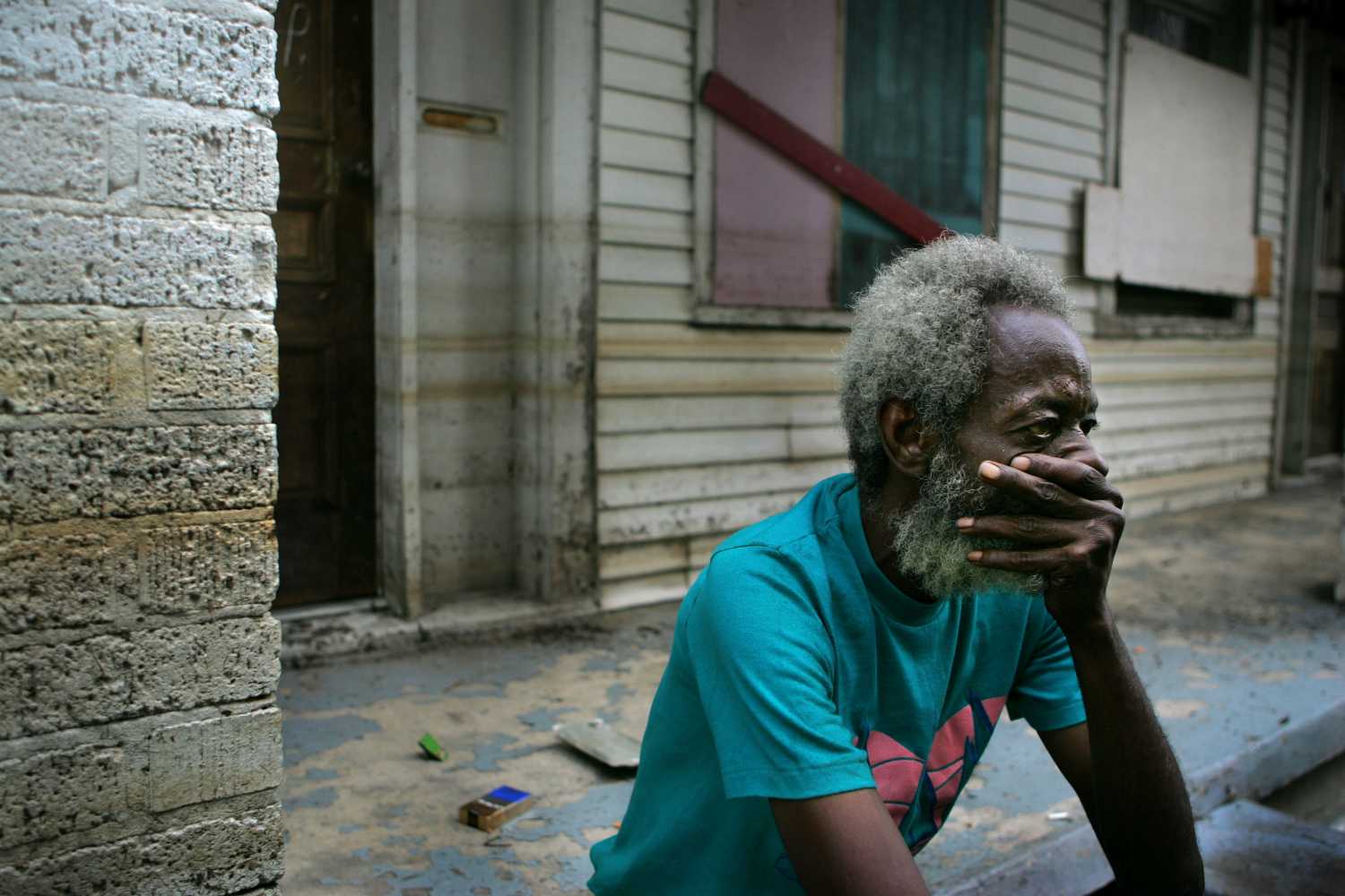 Hurricane Katrina holdout Creek sits on the porch of his house in front of the Memorial Medical Center of New Orleans.  Hurricane Katrina holdout Joshua Creek sits on the porch of his house in front of the Memorial Medical Center of New Orleans September 13, 2005. The discovery of at least 44 bodies in an abandoned hospital in New Orleans raised new questions about the response to Hurricane Katrina on Tuesday as President George W. Bush took full responsibility for government failures in handling the disaster. Pictures of the Year 2005 REUTERS/Carlos Barria