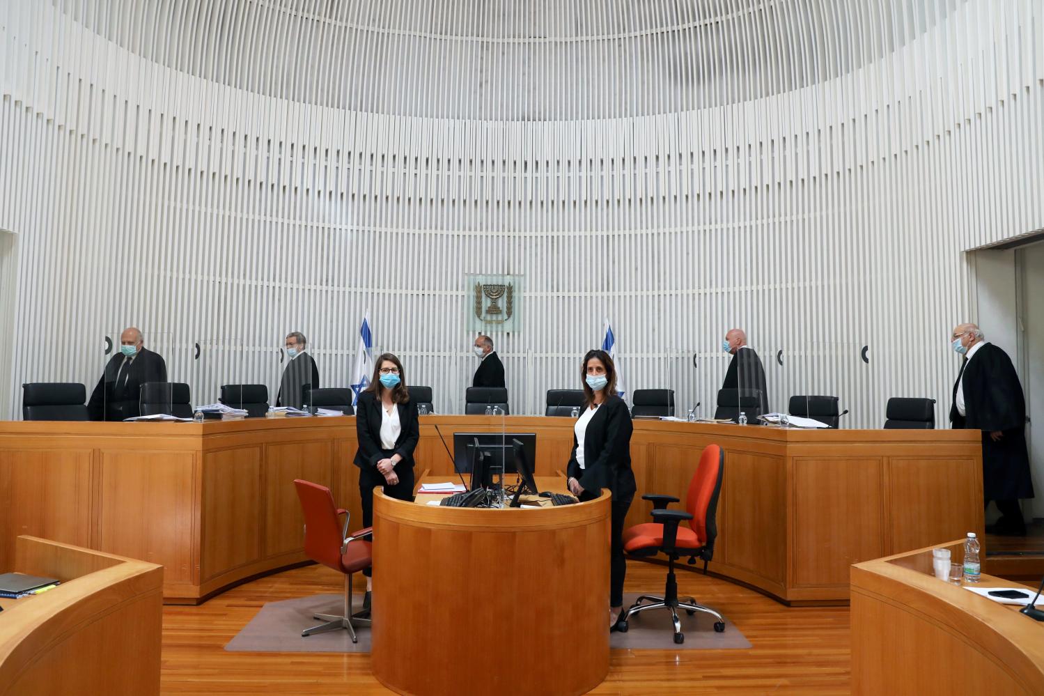 A panel of judges of the Israeli Supreme Court wear face masks as they address a discussion on a petition asking whether Israeli Prime Minister Benjamin Netanyahu can form a government legally and publicly when indictments are filed against him on a charges of fraud, bribery, and breach of trust, at the Israeli Supreme Court in Jerusalem May 4, 2020. Abir Sultan/Pool via REUTERS