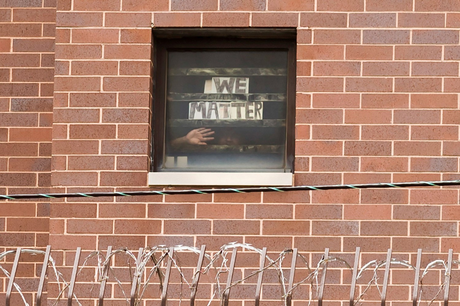 An inmate holds a sign to his cell window reading "We Matter" as Black Lives Matter supporters hold a protest against racial inequality on Father's Day outside Cook County Jail in Chicago, Illinois, U.S. June 21, 2020.  REUTERS/Alexander Gouletas     TPX IMAGES OF THE DAY
