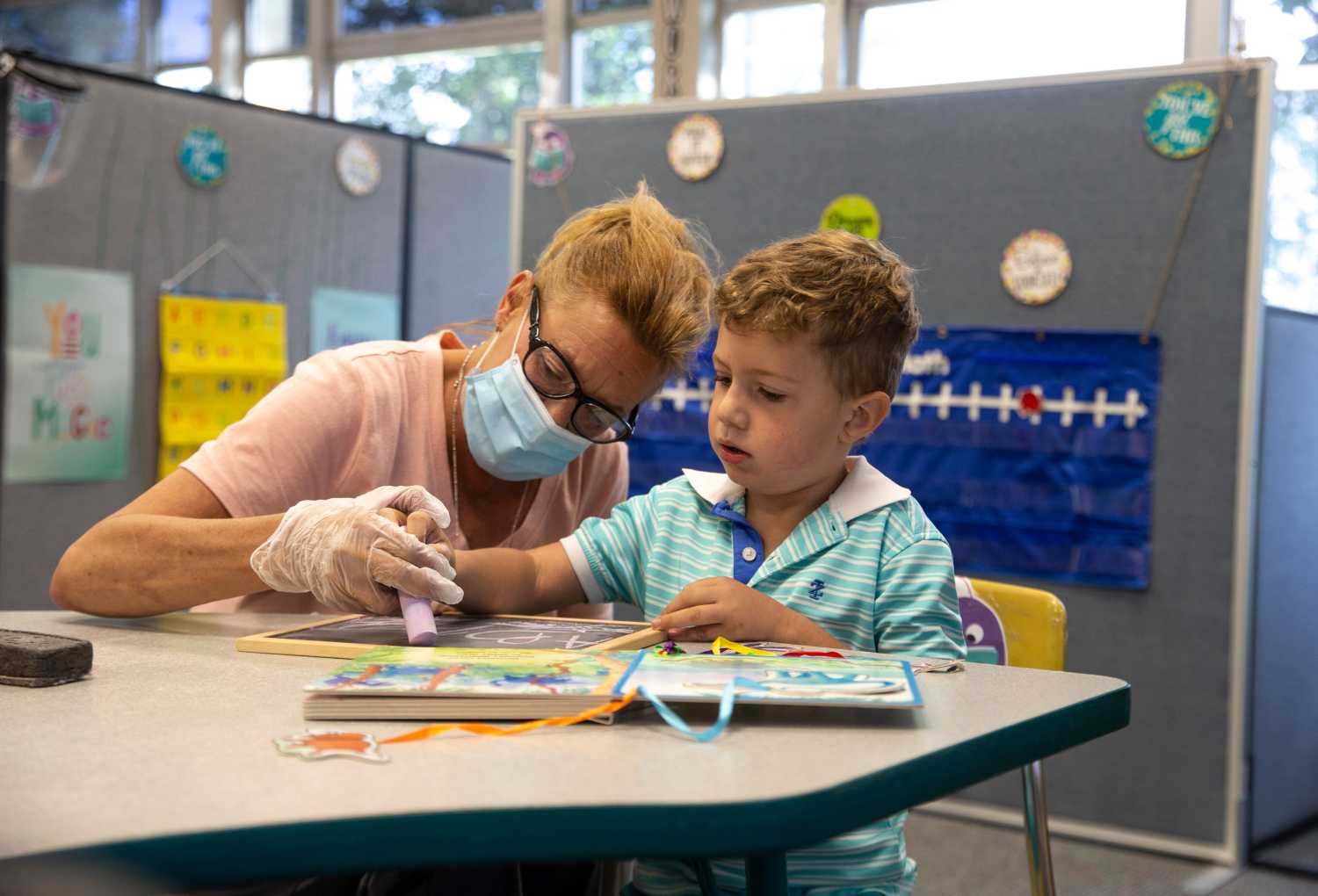 The first day of school gets underway in the Toms River Regional School District. All students receive virtual instruction with the exception of those with special needs. Teachers at Hooper Avenue Elementary School instruct students with the aid of Google Classroom. Mary Amzler, paraprofessional, helps Kindergartener Spencer Santos with handwriting skills. Toms River, NJTuesday, September 8, 2020Trs090820l