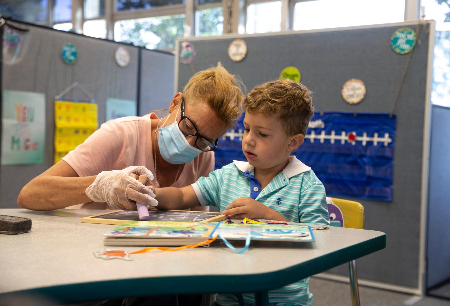 The first day of school gets underway in the Toms River Regional School District. All students receive virtual instruction with the exception of those with special needs. Teachers at Hooper Avenue Elementary School instruct students with the aid of Google Classroom. Mary Amzler, paraprofessional, helps Kindergartener Spencer Santos with handwriting skills. Toms River, NJTuesday, September 8, 2020Trs090820l