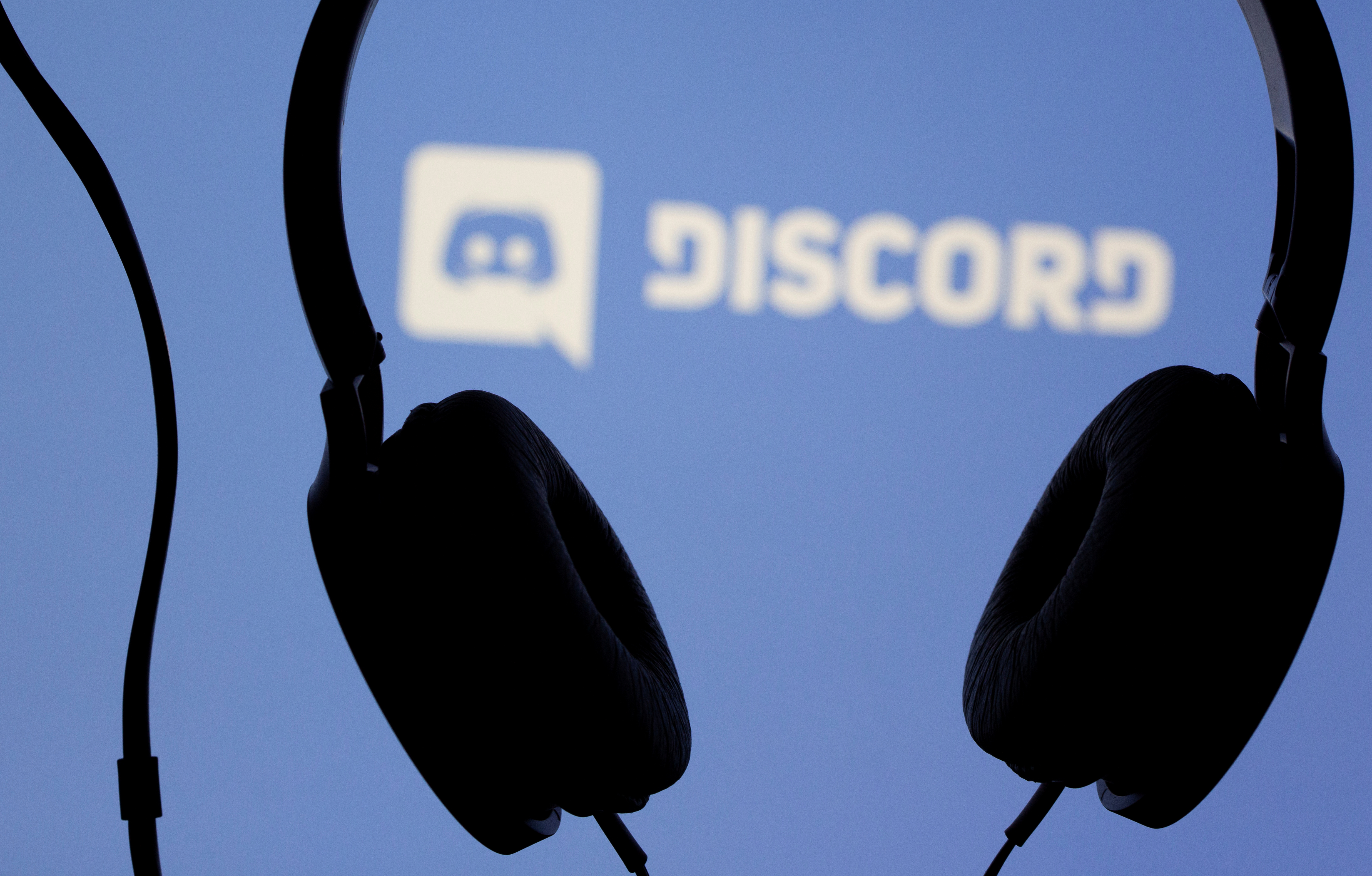 Headphones are seen in front of displayed Discord app logo in this illustration taken March 29, 2021. REUTERS/Dado Ruvic/Illustration