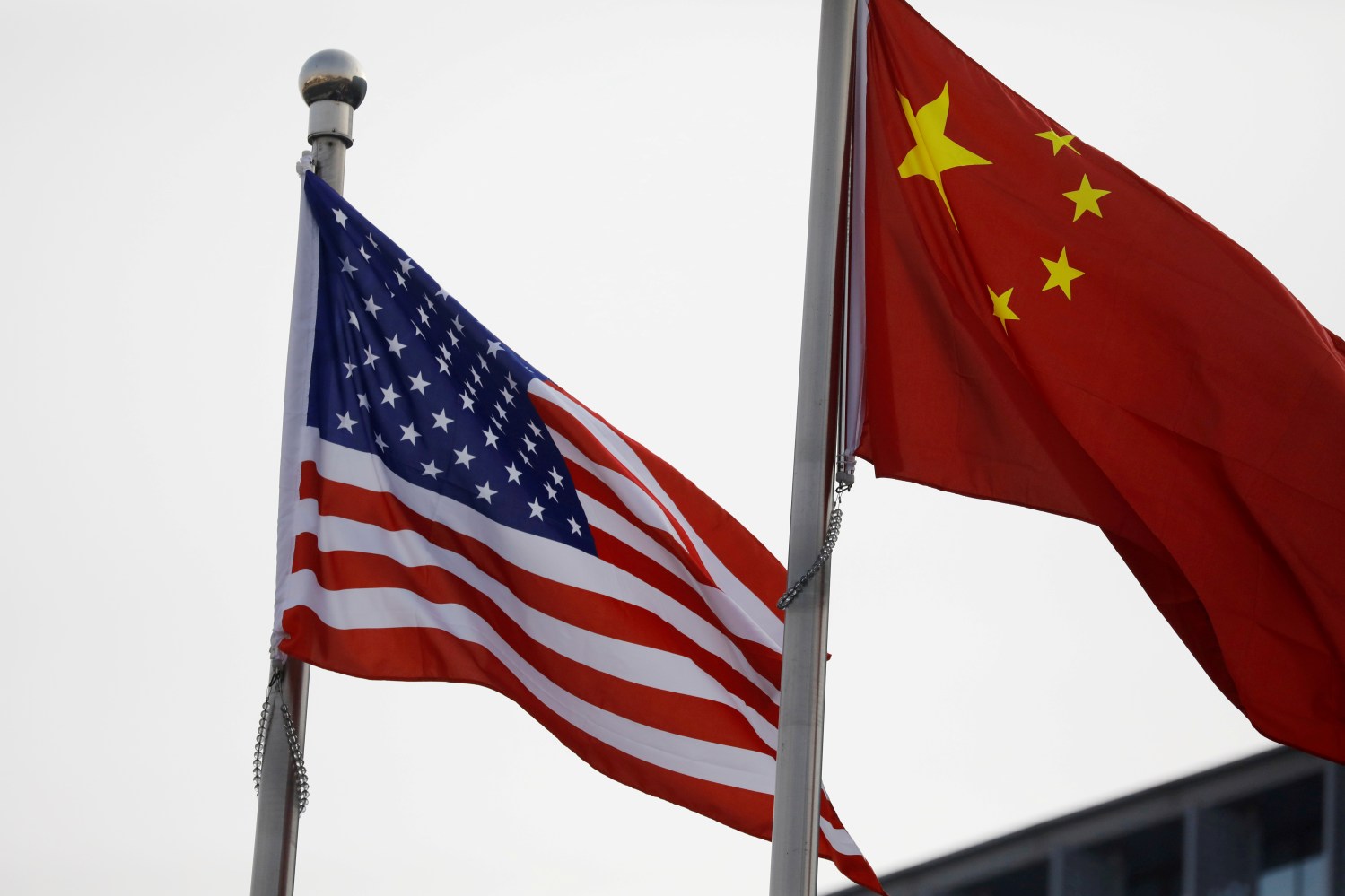 FILE PHOTO: Chinese and U.S. flags flutter outside the building of an American company in Beijing, China January 21, 2021. REUTERS/Tingshu Wang/File Photo/File Photo