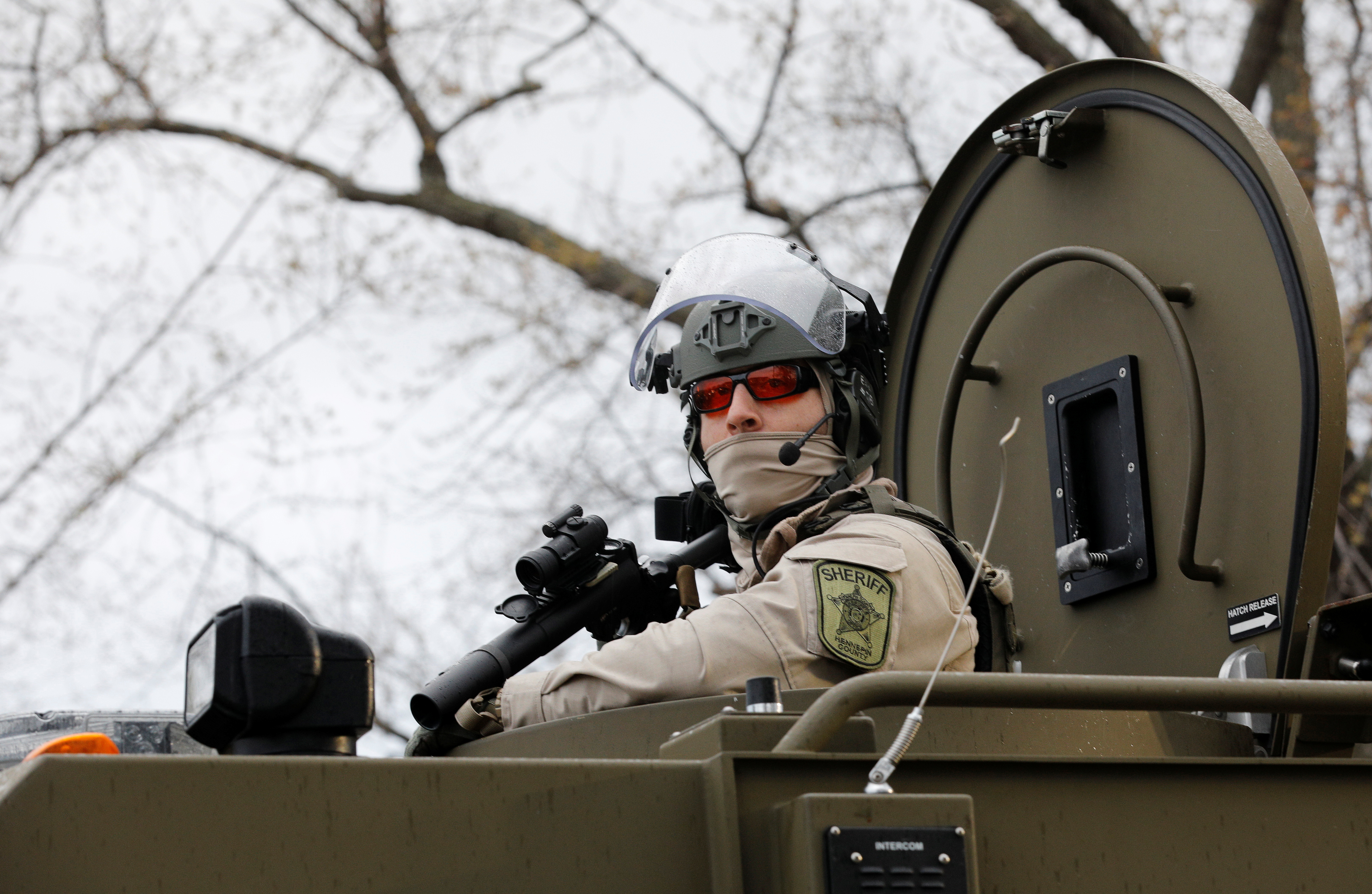 A sheriff's deputy is seen inside an armored vehicle in the fenced up perimeter of the Brooklyn Center Police Department, days after former police officer Kim Potter fatally shot Daunte Wright, in Brooklyn Center, Minnesota, U.S. April 14, 2021. REUTERS/Nick Pfosi