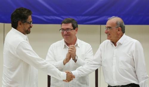 Colombia's FARC lead negotiator Ivan Marquez (L) and Colombia's lead government negotiator Humberto de la Calle (R) shake hands while Cuba's Foreign Minister Bruno Rodriguez looks on, after signing a final peace deal in Havana, Cuba, August 24, 2016. REUTERS/Alexandre Meneghini     TPX IMAGES OF THE DAY