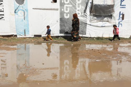 Syrian refugees walk near tents at an informal tented settlement in the Bekaa valley, Lebanon March 12, 2021. Picture taken March 12, 2021. REUTERS/Mohamed Azakir