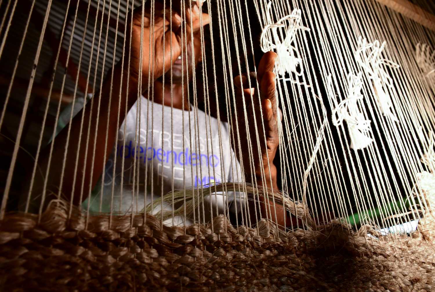 A worker weaves a carpet from the fibre extracted from the sheaths of banana trunks at the TexFad plant in Sonde settlement of Mukono near Kampala, Uganda, April 3, 2021. Picture taken April 3, 2021. REUTERS/Abubaker Lubowa