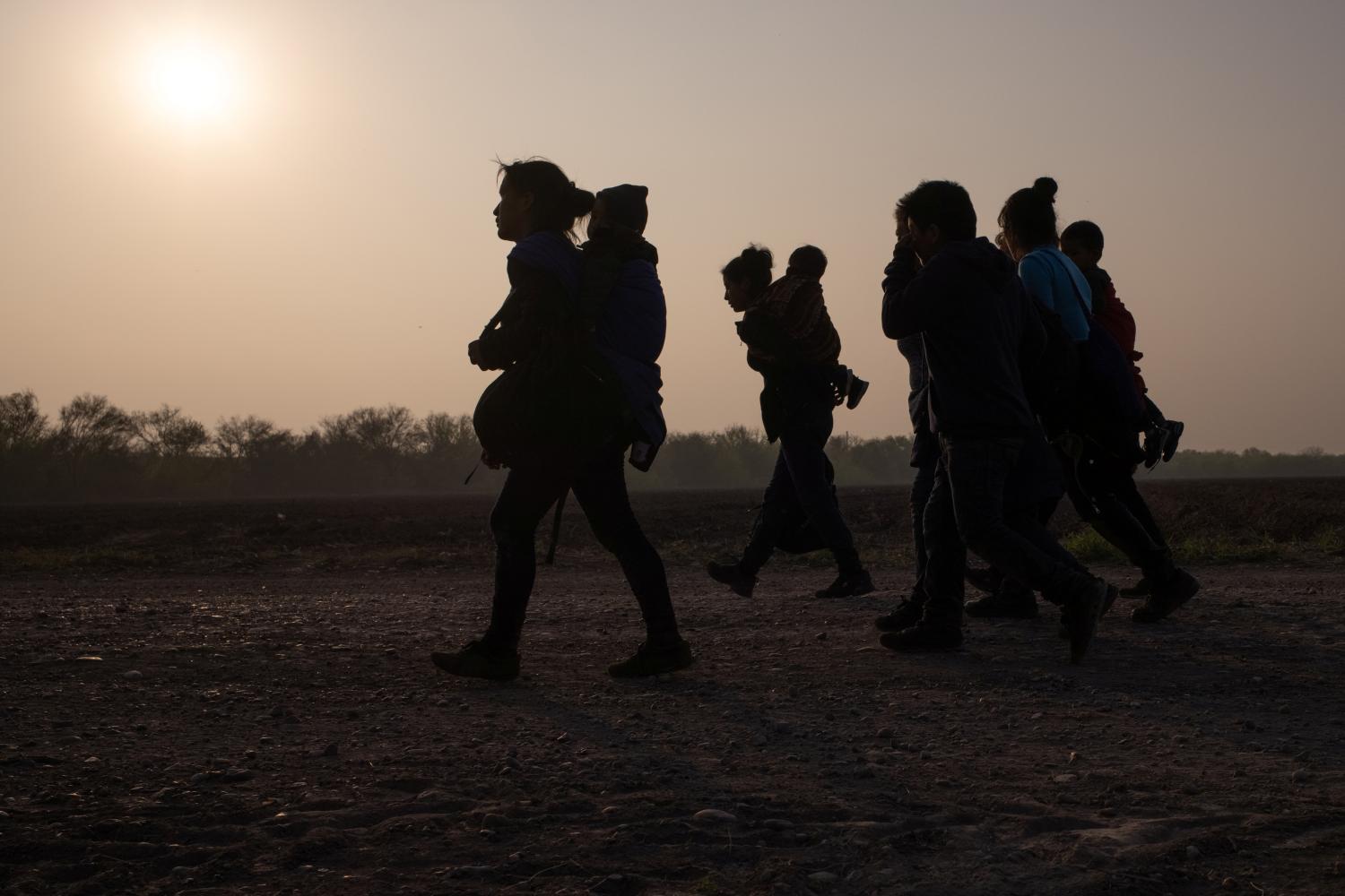 Asylum-seeking mothers from Guatemala and Honduras carry their children after they crossed the Rio Grande river into the United States from Mexico on a raft, in Penitas, Texas, U.S., March 17, 2021. REUTERS/Adrees Latif