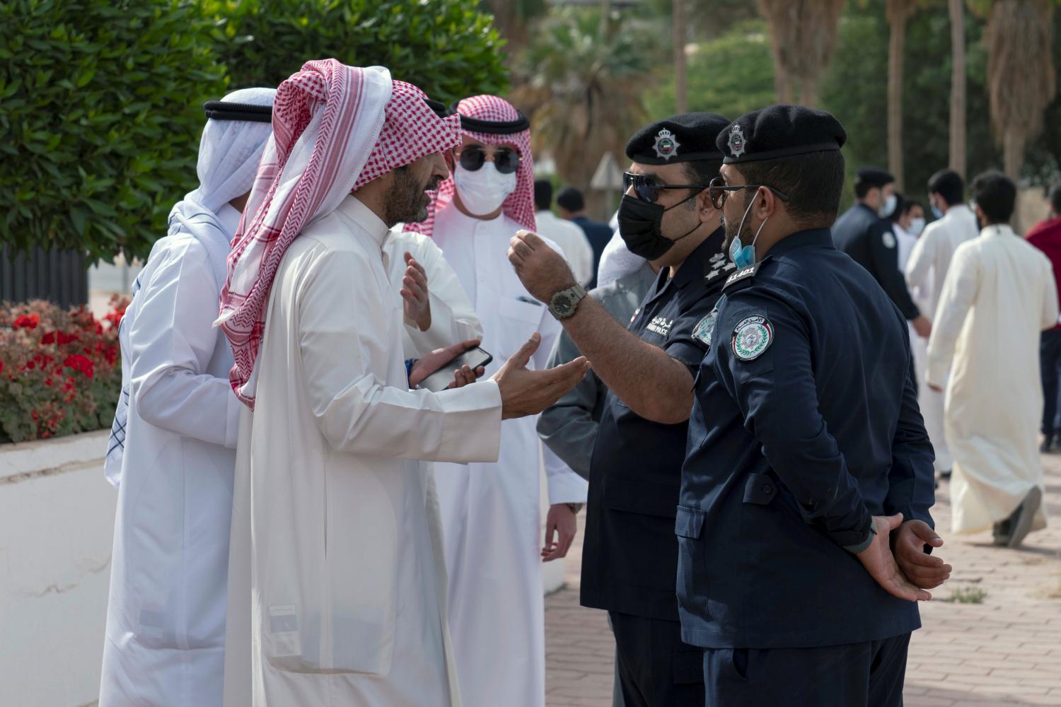 Demonstrators speak with police officers as they gather in front of Kuwait National Assembly building to protest against the nullification of Bader al-Dahoum's membership in the parliament, in Kuwait City, Kuwait, March 30, 2021.  REUTERS/Stephanie McGehee