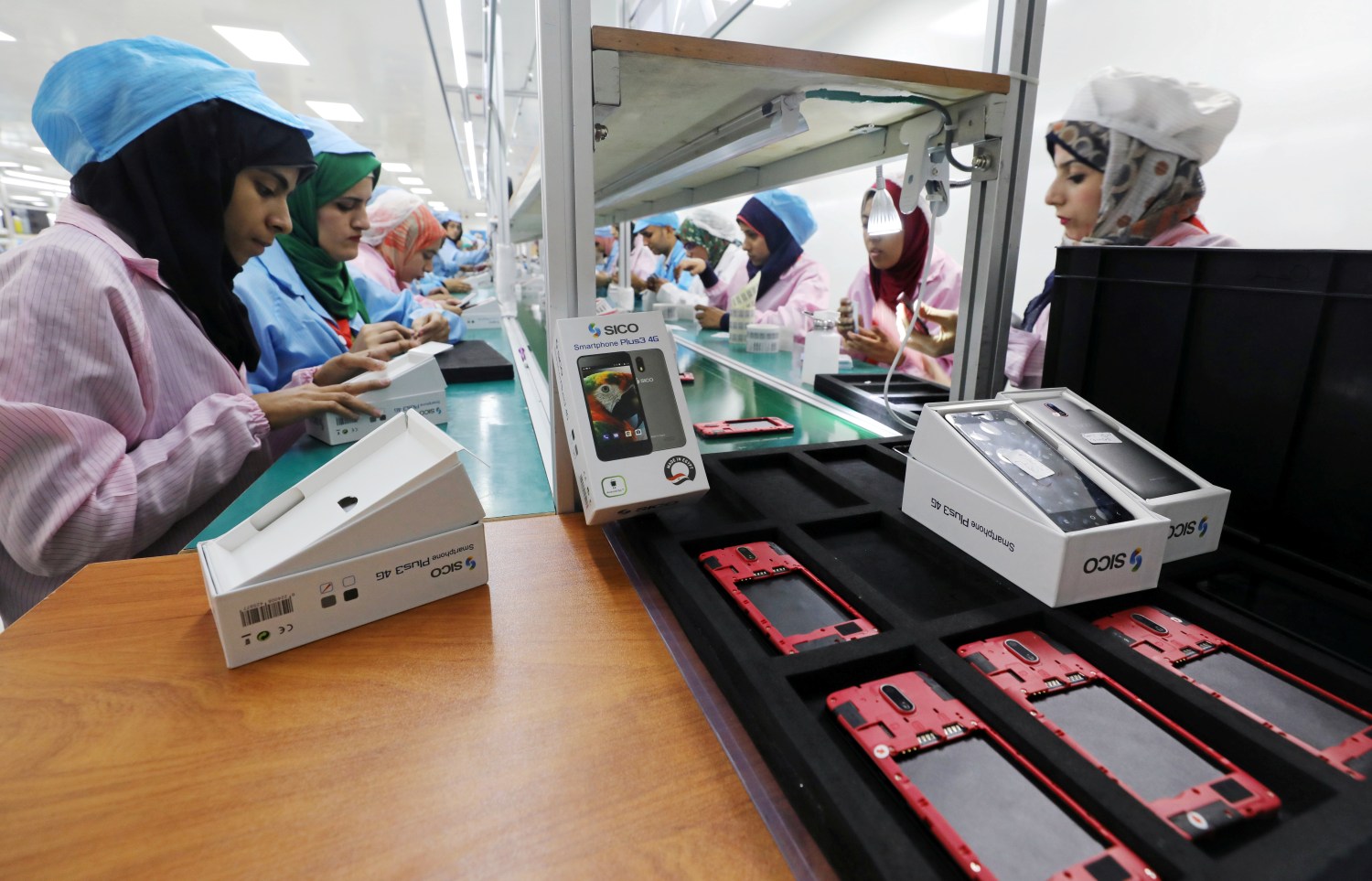 Women work on a production line at the mobile phone factory in Assuit, Egypt September 30, 2018. Picture taken September 30, 2018. REUTERS/Mohamed Abd El Ghany - RC1DC3804970