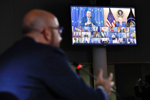 U.S. President Joe Biden and President of the European Council Charles Michel are seen on a large television screen attending a virtual summit.