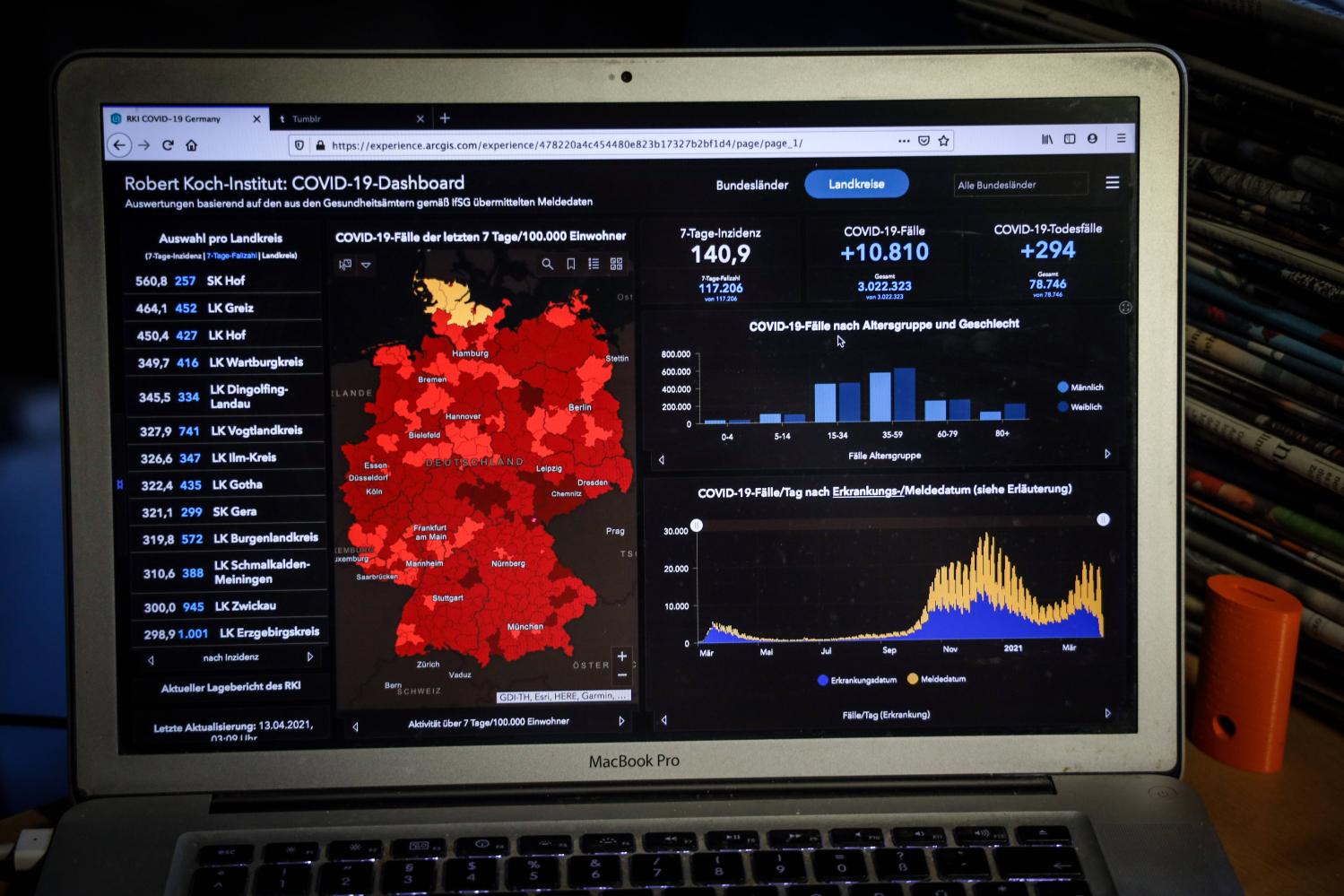 A photograph of a laptop displaying the the Robert Koch Institute's COVID-19 dashboard for April 13, 2021.