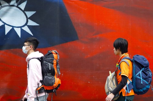 Taiwanese people walk past a huge banner with a Taiwan national flag amid increased tensions with China, in Taipei, Taiwan. With more jet fighters cruising around the island sent by Beijing, Taiwan foreign minister Joseph Wu has said Taiwan will defend itself to the “very last day” whilst it has been fostering relationship with the United States on military, economy, technology and medical services.Where: Taipei, TaiwanWhen: 13 Apr 2021Credit: Daniel Ceng/Cover Images