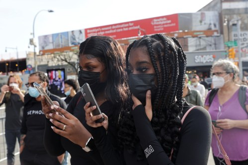 Kimora Miller and Shamyia Brown (both 18) hold their phones as the verdict in the trial of former Minneapolis police officer Derek Chauvin, who is facing murder charges in the death of George Floyd, is announced, at the Barclays Center in Brooklyn, New York City, New York, U.S., April 20, 2021. REUTERS/Jeenah Moon