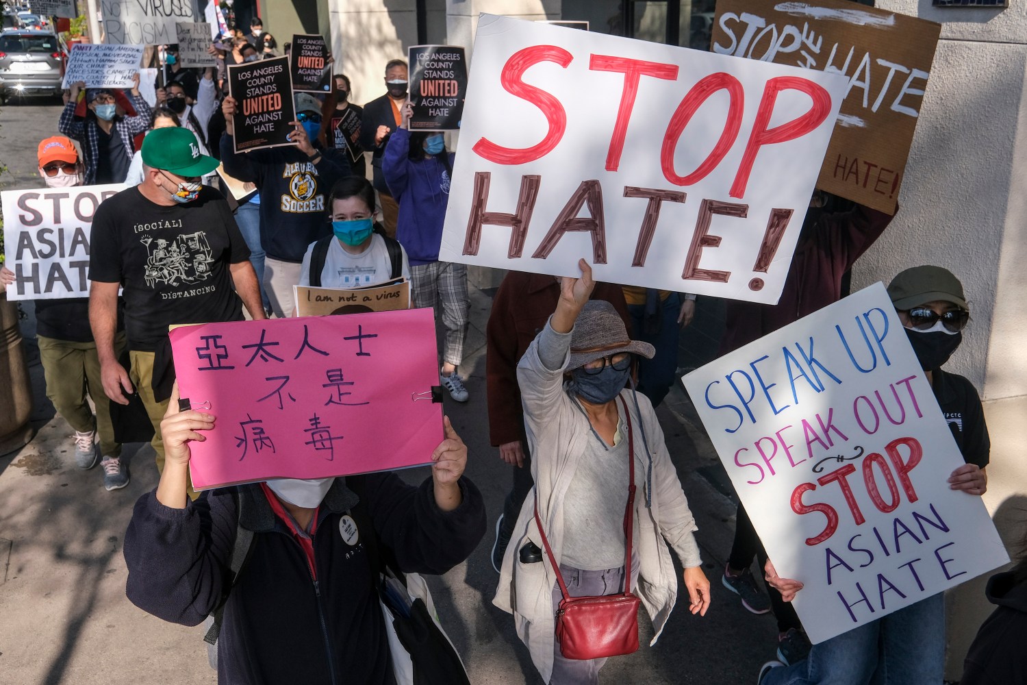 Crowd of protestors with signs related to anti-Asian discrimination..