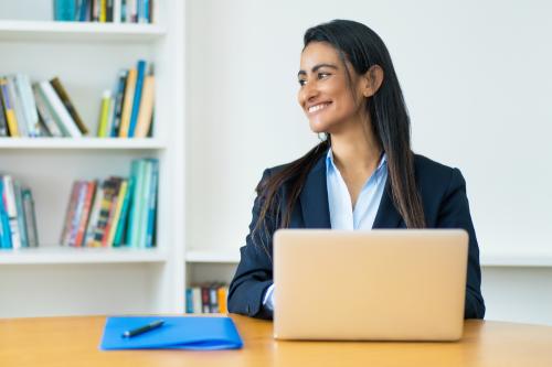 Businesswoman wearing blazer with computer and folder at office
