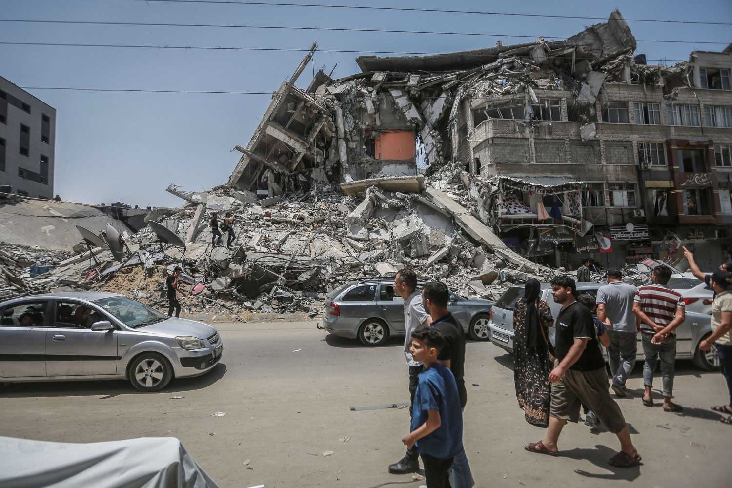 Palestinians inspect damaged buildings that were hit by Israeli airstrikes during the recent military conflict between Israel and the Palestinian enclave controlled by Hamas. Israel and Hamas have reached an agreement on the ceasefire after days of fighting in which around 230 Palestinians were killed in Israeli airstrikes and 12 people in Israel were killed by rocket fire from the Gaza Strip.