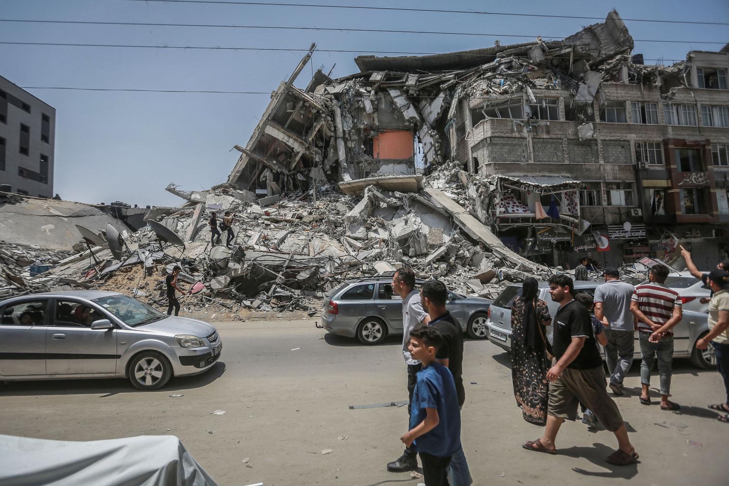 Palestinians inspect damaged buildings that were hit by Israeli airstrikes during the recent military conflict between Israel and the Palestinian enclave controlled by Hamas. Israel and Hamas have reached an agreement on the ceasefire after days of fighting in which around 230 Palestinians were killed in Israeli airstrikes and 12 people in Israel were killed by rocket fire from the Gaza Strip.