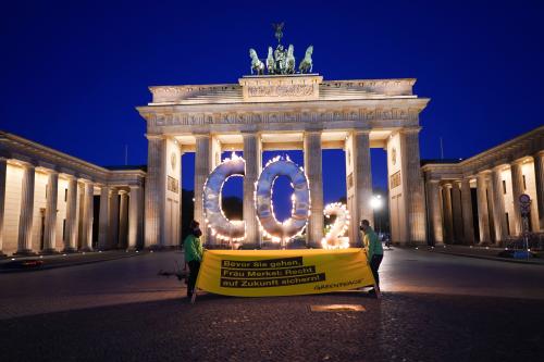 During a Greenpeace action, a CO-2 sign stands in front of the Brandenburg Gate with flames coming out of it. Two demonstrators hold a banner with the words "Before you go Mrs Merkel: Secure the future". With the action, activists of the environmental protection organization call on the German government to further reduce CO-2 emissions in Germany and to ensure compliance with the goals of the world climate summit in Paris.