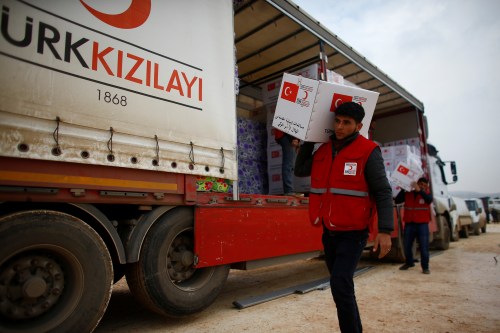 Turkish Red Crescent workers carry humanitarian aid at Kelbit camp, near the Syrian-Turkish border, in Idlib province, Syria January 17, 2018. Picture taken January 17, 2018. REUTERS/Osman Orsal