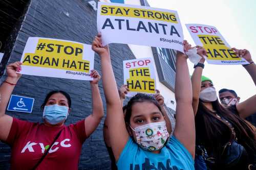 Melanie Bolanos, 9, holds a sign to protest hate crimes committed against Asian-American and Pacific Islander communities ahead of a car caravan in Koreatown on March 19, 2021 in Los Angeles.