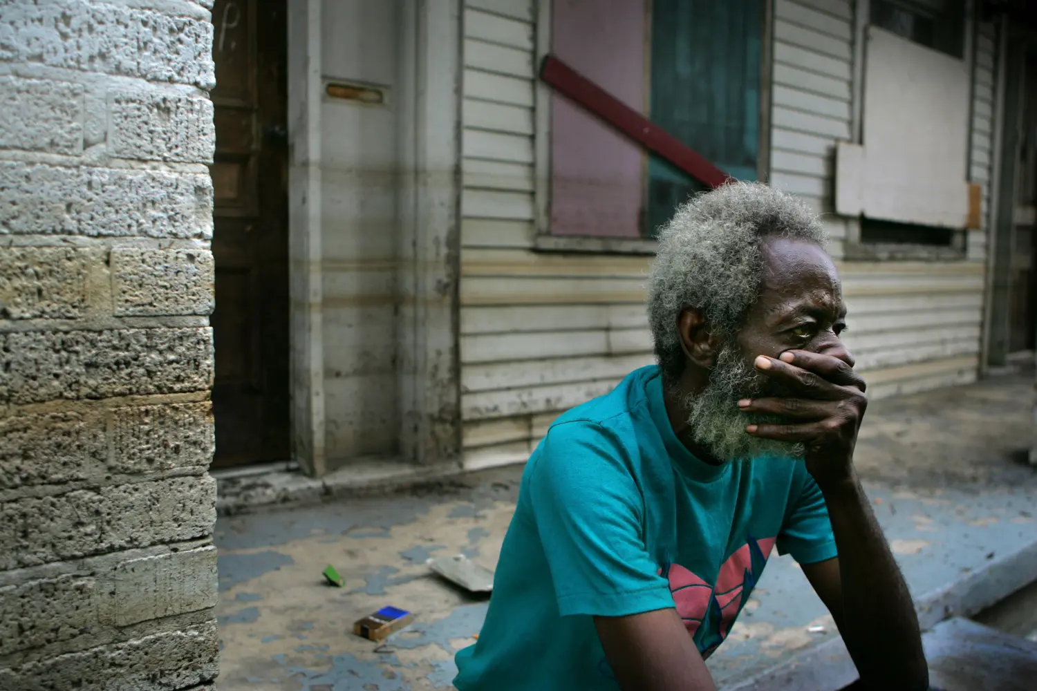 Hurricane Katrina holdout Creek sits on the porch of his house in front of the Memorial Medical Center of New Orleans.  Hurricane Katrina holdout Joshua Creek sits on the porch of his house in front of the Memorial Medical Center of New Orleans September 13, 2005. The discovery of at least 44 bodies in an abandoned hospital in New Orleans raised new questions about the response to Hurricane Katrina on Tuesday as President George W. Bush took full responsibility for government failures in handling the disaster. Pictures of the Year 2005 REUTERS/Carlos Barria