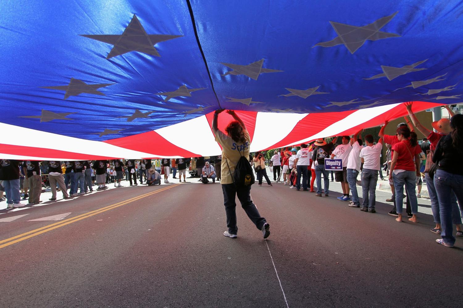 Participants carry a large U.S. flag during a march for immigration reform in Hollywood, Los Angeles, California, October 5, 2013. REUTERS/David McNew (UNITED STATES - Tags: CIVIL UNREST SOCIETY IMMIGRATION POLITICS)