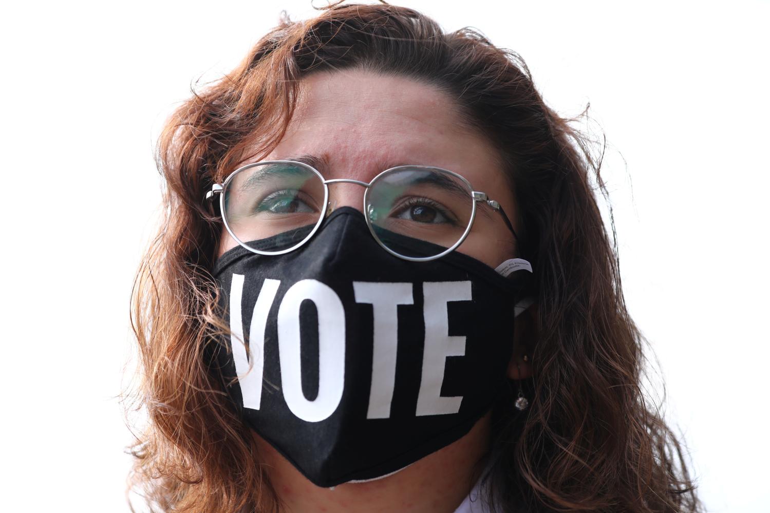 A woman wearing a protective face mask looks on during a Latino voter registration event in Lilburn, Georgia, U.S. December 7, 2020. REUTERS/Dustin Chambers